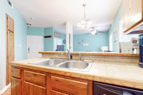 a kitchen with a stainless steel sink and blue walls at Lyla's Beach Getaway in Padre Island