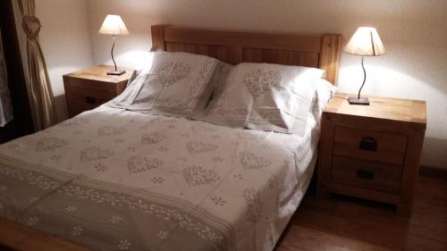 ein Schlafzimmer mit einem Bett mit zwei Nachttischen und zwei Lampen in der Unterkunft Le Bivouac in Sixt