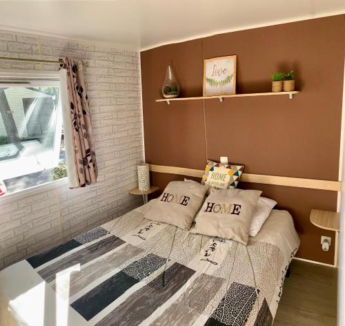 a small bedroom with a bed and a window at Mobil home « lysea », 6p, Clim in Agde