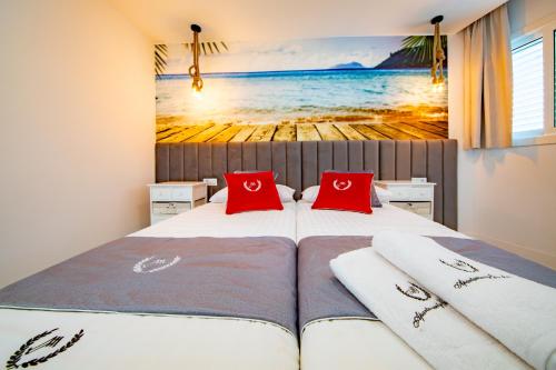 Un dormitorio con dos camas con almohadas rojas. en Ponderosa 615, Las Americas, one bedroom apartment with large terrace and ocean view, next to Siam Park, en Playa de las Américas