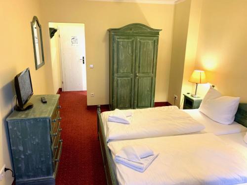 a bedroom with two beds and a green cabinet at Hotel See-Eck in Heringsdorf