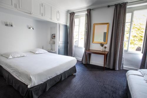 ein Schlafzimmer mit einem großen weißen Bett und einem Spiegel in der Unterkunft Hôtel Brasserie du Parc in Albi