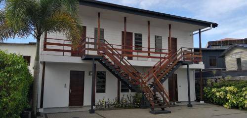 a house with a staircase on the side of it at Bij BRAKKE in Paramaribo