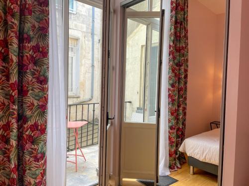 a room with a door open to a balcony at L'Amiral T3 de 100m2 tout neuf in La Rochelle