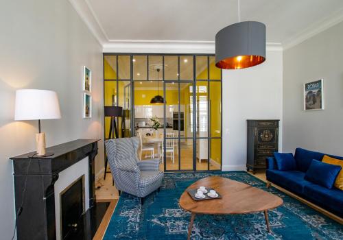 un salon avec un canapé bleu et une cheminée dans l'établissement L'Amiral T3 de 100m2 tout neuf, à La Rochelle