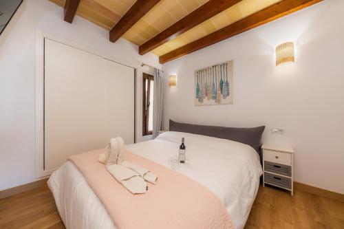 a bedroom with a bed with a bottle of wine on it at Sa Figuereta Living Place in Ariany