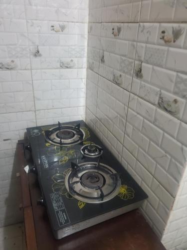 a stove top in a room with white tiles at Comfy zone in Abu Dhabi