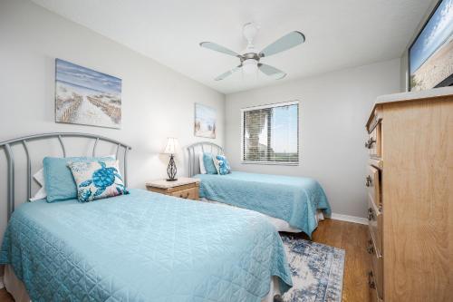 um quarto com 2 camas e uma ventoinha de tecto em Summerhouse 263, 2 Bedrooms, Sleeps 6, Ocean Front, 4 Heated Pools, WiFi em Saint Augustine