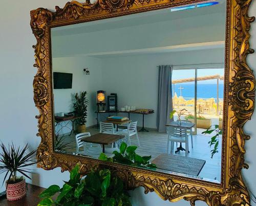 um espelho que reflecte uma sala de estar com uma mesa e cadeiras em Il Tramonto em Calvi