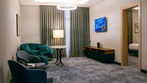 a room with chairs and a table and a bed at Wyndham Garden Baku in Baku
