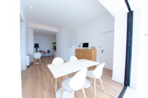 a white dining room with a white table and white chairs at Pascià Boutique Hotel in Ragalna