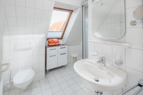 ein weißes Bad mit einem Waschbecken und einem WC in der Unterkunft Haus Dwarslooper - Wohnung Lüntje in Norderney