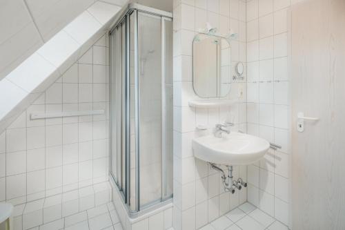 ein Bad mit einem Waschbecken und einer Dusche in der Unterkunft Haus Dwarslooper - Wohnung Lüntje in Norderney