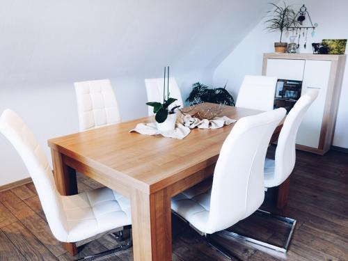 a dining room table with white chairs around it at Auf dem Worbelchen in Monschau