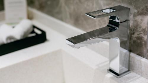 a bathroom sink with a chrome bathroom faucet at Wyndham Garden Baku in Baku