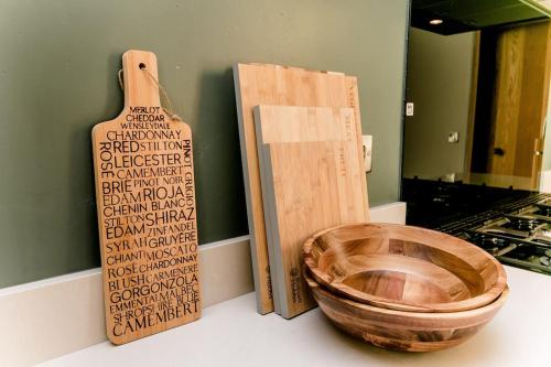 a wooden bowl sitting on a counter next to a cutting board at Beautiful Barn Conversion Close To The Broads in Dilham