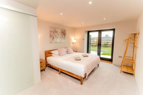 a bedroom with a bed with a ladder and a window at Beautiful Barn Conversion Close To The Broads in Dilham