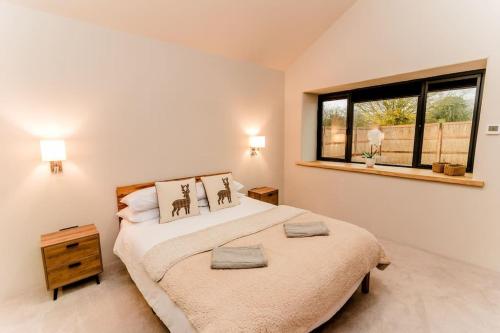 a bedroom with a large bed and a window at Beautiful Barn Conversion Close To The Broads in Dilham