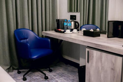a blue chair sitting at a table in a hotel room at Wyndham Garden Baku in Baku