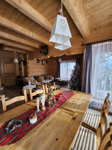 un salon avec une table en bois et des arbres de Noël dans l'établissement Góralska Chatka z Balią 2 - ZAKOPANE, à Zakopane