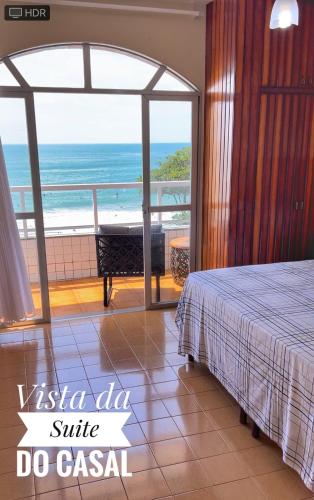 a bedroom with a bed and a view of the ocean at Ap401 Praia do morro in Guarapari