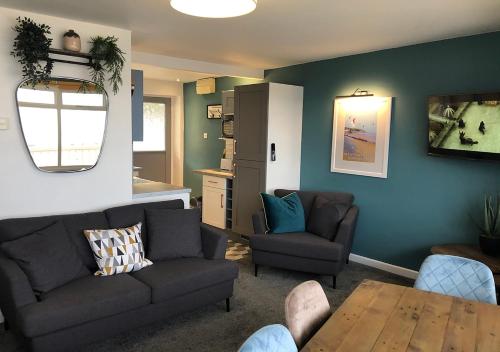 a living room with two couches and a table at Braddicks Holidays - Sea View Apartments & Caravans in Westward Ho