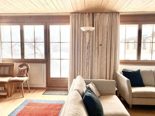 a living room with a couch and some windows at Hotel Ducan in Monstein
