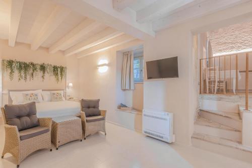 a bedroom with a bed and a chair and a television at Palazzo Montanari Art & Wine Luxury Apartments in Fumane