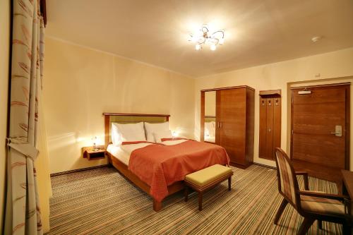 Pokój hotelowy z łóżkiem i krzesłem w obiekcie Parkhotel Forest w Mariańskich Łaźniach