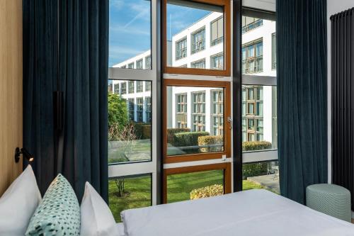 a bedroom with a bed and a large window at Clipper Boardinghouse - Hamburg-Michel in Hamburg