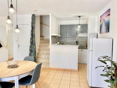 une cuisine et une salle à manger avec une table et un réfrigérateur dans l'établissement Beaux Arts T3 Duplex, Rénové Lumineux + Garage, à Montpellier