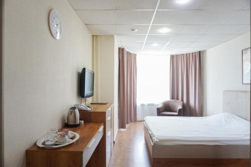 um quarto de hotel com uma cama e uma televisão em City Hotel em Ecaterimburgo