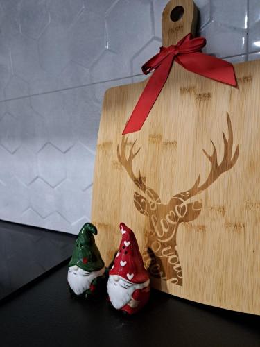a wooden christmas house with two reindeer decorations on it at ŁośHouse in Bytów