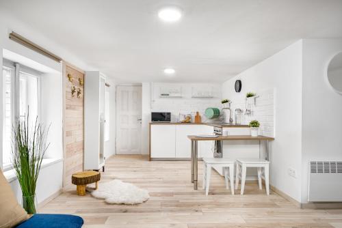 cocina y comedor con armarios blancos y mesa en COSY COTTAGE - Cheerful Apartment in the Center en Budapest