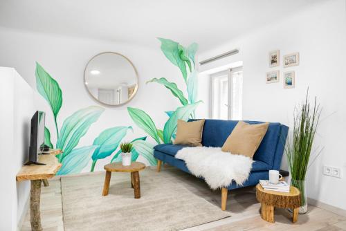 COSY COTTAGE - Cheerful Apartment in the Center في بودابست: غرفة معيشة مع أريكة زرقاء ومرآة