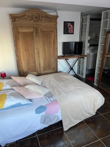 een bed met een houten hoofdeinde in een kamer bij Propriétaire privé in Carcassonne