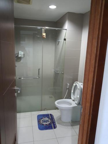 a bathroom with a toilet and a glass shower at 2BR Apt Springhill Terrace, Golf View in Jakarta