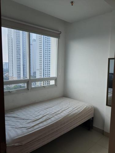 a white room with a bed and a large window at 2BR Apt Springhill Terrace, Golf View in Jakarta