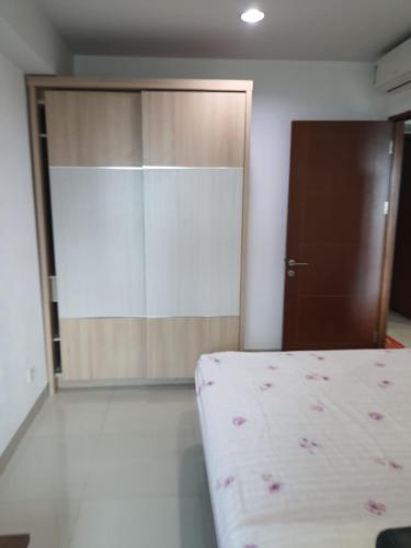 um quarto com uma cama e uma porta de madeira em 2BR Apt Springhill Terrace, Golf View em Jakarta