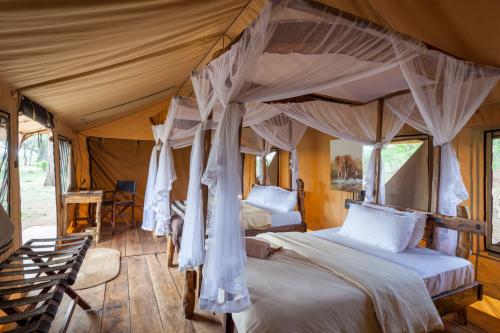 a bedroom with two beds in a tent at Baobab Tented Camp in Kwa Kuchinia