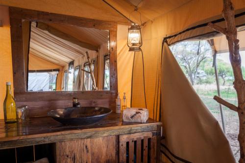 uma casa de banho com um lavatório e um espelho em Baobab Tented Camp em Kwa Kuchinia
