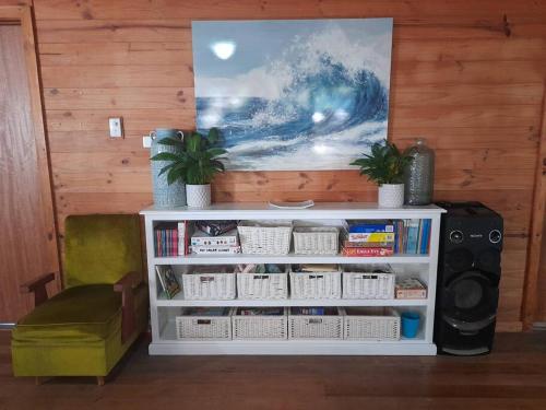 a white book shelf in a room with a painting at Bells Beach Family Retreat in Bellbrae