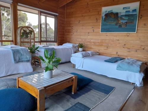 a living room with two beds and a table at Bells Beach Family Retreat in Bellbrae