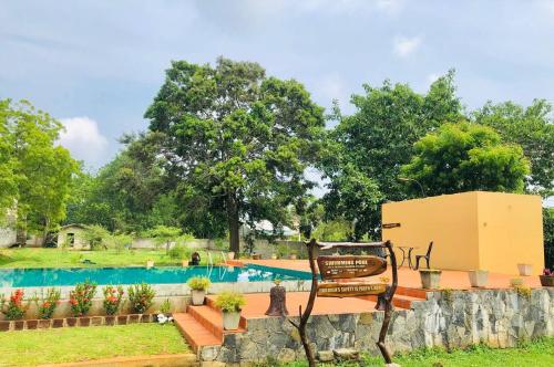 a resort with a swimming pool and a bench at Lolu Village Resort in Anuradhapura