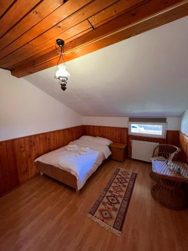 a bedroom with a bed and a wooden ceiling at Casa Aramis in Azuga