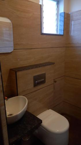 een badkamer met een wit toilet en een wastafel bij Greenpark Residence in Mama
