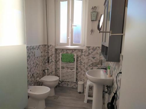 bagno con due servizi igienici, lavandino e finestra di Grande casa vicina al centro a Firenze