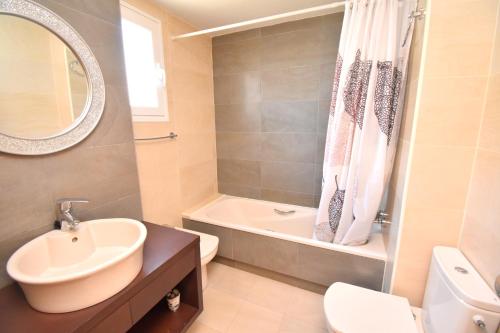 a bathroom with a sink and a tub and a toilet at Apartamento Golden Gardens in Jávea