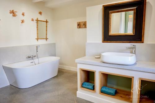 a bathroom with a tub and a sink and a bath tub at La maison de Saint-Ké - Les gîtes de Keregal in Saint-Quay-Portrieux