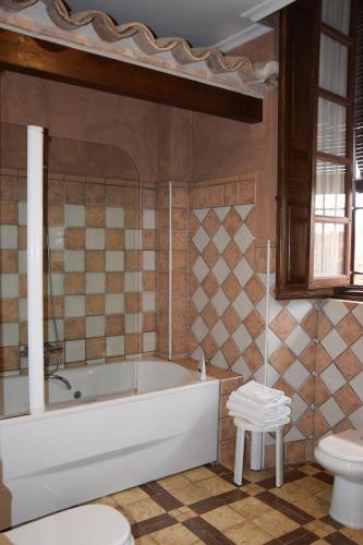 een badkamer met een bad, een toilet en een wastafel bij Palacio del Gobernador in Moral de Calatrava